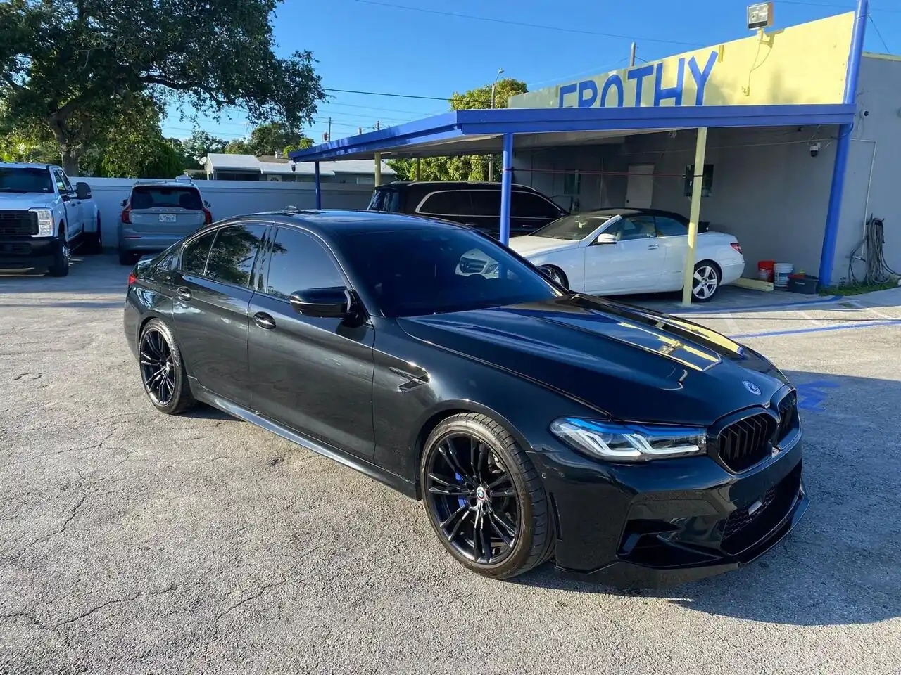 Black BMW M5 front three-quarter view, glossy finish