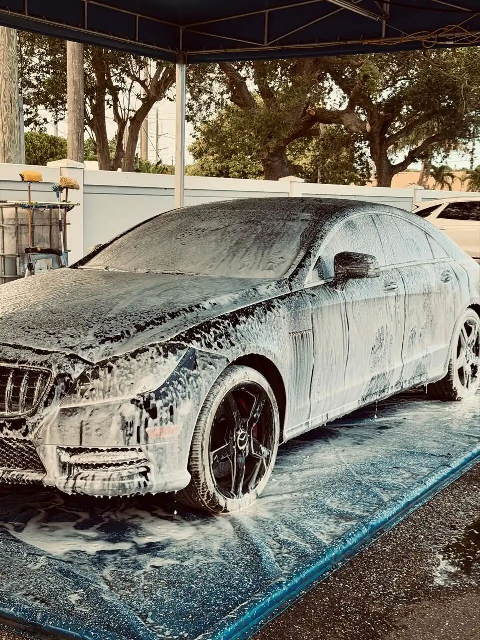 Black Maserati covered in foam during a hand wash