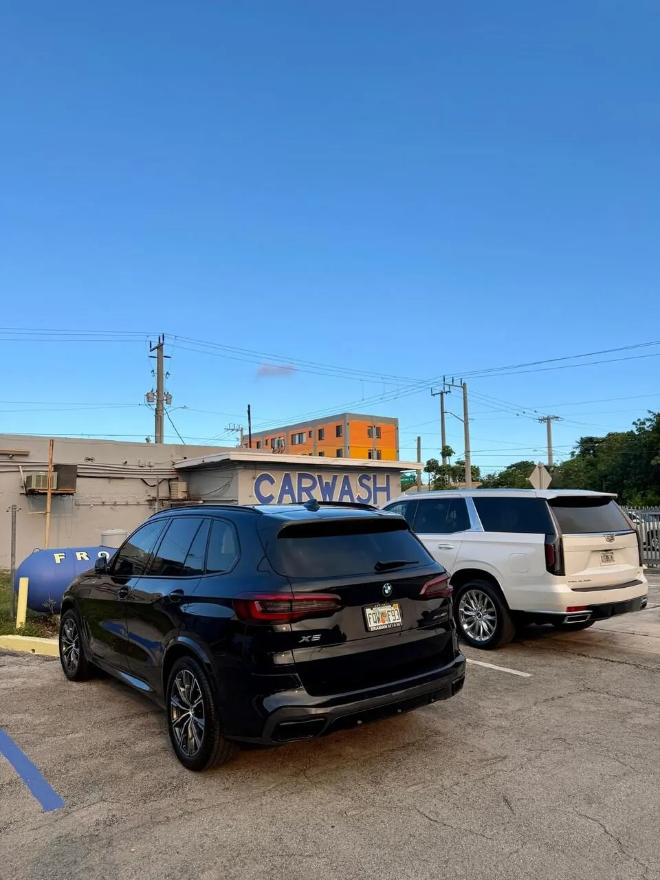 Black SUV and white truck parked at Frothy