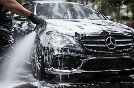 Hand suds wash on a black Mercedes-Benz