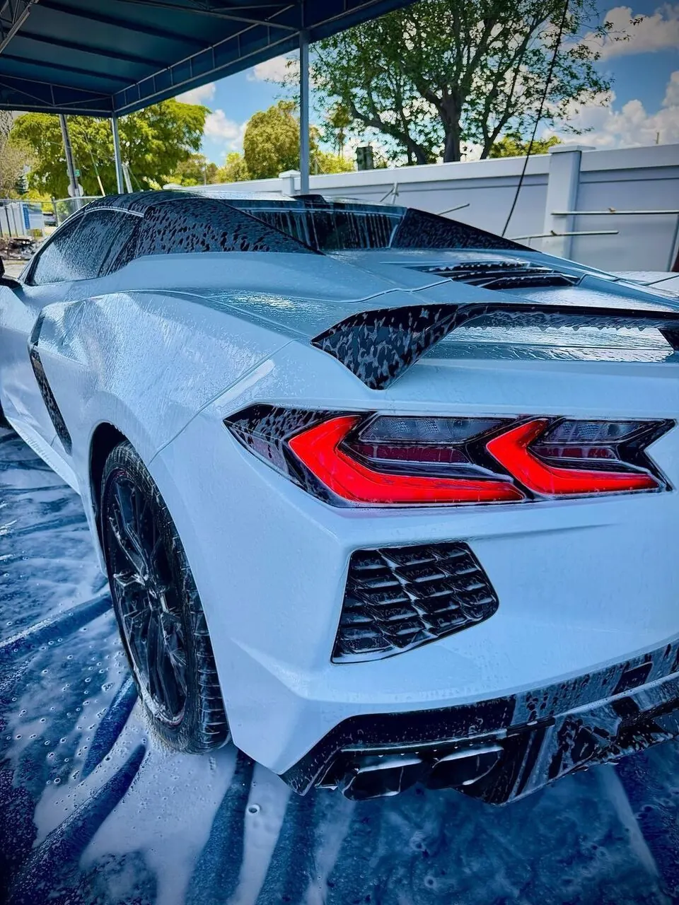 White Corvette covered in foam, rear close-up